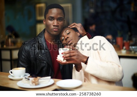 Portrait of young beautiful couple in love having coffee in beautiful cafe, two people in cafe enjoying the time spending with each other