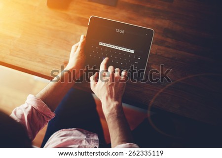 Cropped shot of a man\'s hands using a digital tablet at office, on-line shopping at home, cross process, filtered image, flare sun light, data security