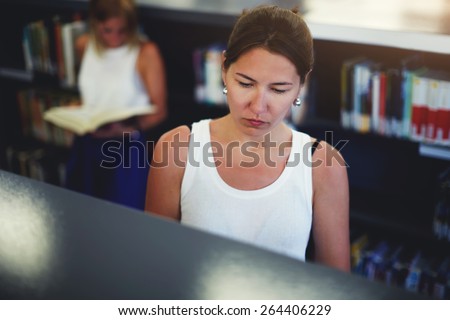 Portrait of young asian female searching book on bookshelves, attractive chinese walking in university library,female freelancers in co-working space looking for some book,students at exam preparation