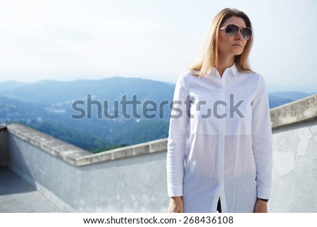 Half length portrait of young woman posing for vacation photo on mountains view background