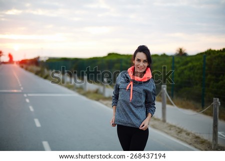 Attractive female runner taking a break after intensive run outdoors