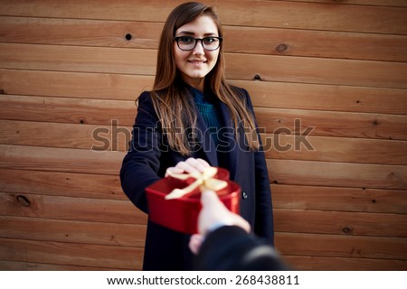 First person view with surprised cheerful woman taking Saint Valentine\'s present from her boyfriend looking to the camera