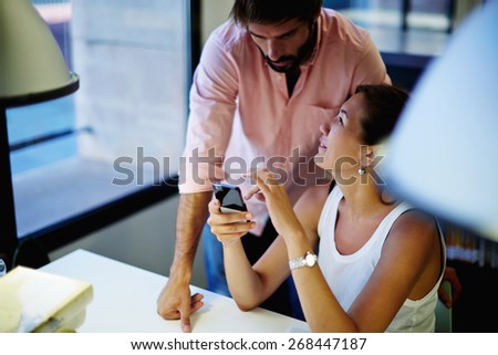 Business people having conversation while working in modern loft co-working space, young asian woman holding her smart phone while talking with her colleague, students in library using technology