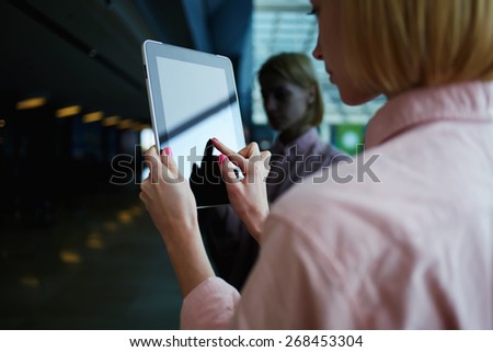 Side view female person using digital tablet, business woman or freelancer working on touch pad in elevator, businesswoman using her wireless devices in modern office, young successful browsing on pad