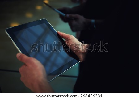Cropped shot of male person using a digital tablet, man\'s hand typing text message zooming digital image on touchpad, businessman using his wireless devices during a meeting, work on a tablet screen