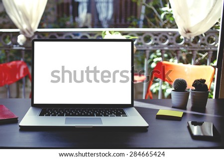 Workplace with open computer, colorful notebooks and stickers, laptop with blank copy space empty screen for your content or text message, modern table at open window in home interior in summer,filter