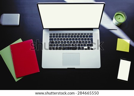 Top view of workplace with open laptop, colorful notebooks and stickers, computer with blank copy space screen for your information or content, modern table at window in home interior, distance work
