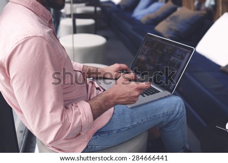 Cropped image male person connecting to wireless on his laptop computer during coffee break in modern interior, male freelancer using smart phone while sitting in cafe, entrepreneur working on devices