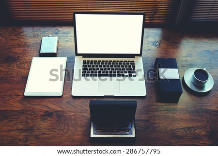 Freelancer needs workstation with accessories and cup of coffee, open laptop computer and digital tablet with blank copy space screen for text information or content, on-line learning or distance work