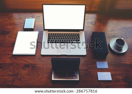 Successful businessman or entrepreneur table with style accessories, pen case, open laptop computer and digital tablet with white blank copy space screen for text information or content, e-business