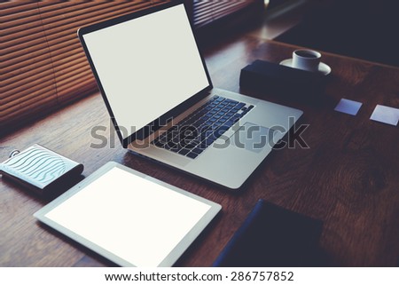 Successful businessman or entrepreneur wooden table with style accessories, open laptop computer and digital tablet with white blank copy space screen for text information or content,e-business,filter