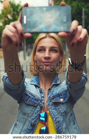 Female tourist using mobile phone camera for take a picture of herself during vacation holidays in Barcelona, stylish young woman taking self portrait with smart phone,feeling good and happy in travel