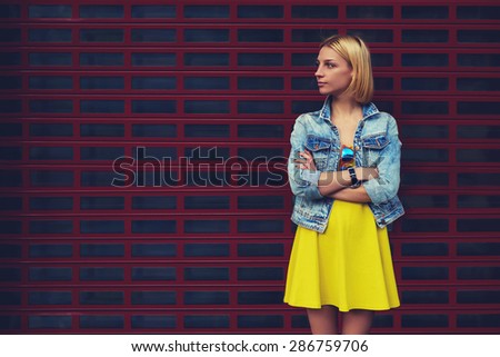 Portrait of attractive young woman standing on blank copy space background for your text message or content, stylish female looking to the space for your promotion or publicity information, filter