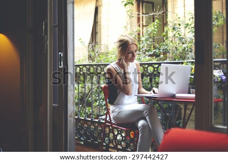 Young successful freelancer girl work on her laptop while sitting at home balcony, intelligent attractive female student using computer for browse Internet and listen to music with headphones