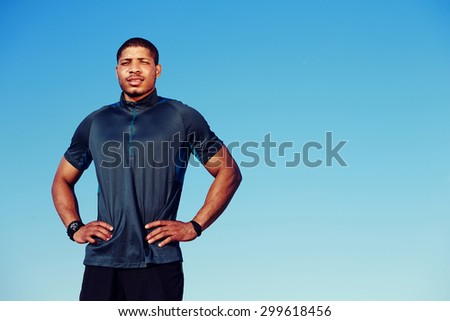 Muscular build handsome athlete resting after a morning run standing against blue sky background with copy space area for your text message information, afro american runner took a break after workout