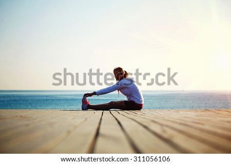 Woman runner doing exercises for the muscles of the body after an active run