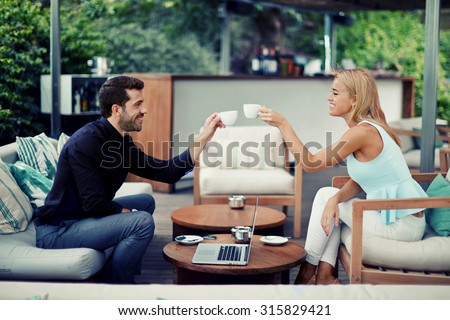 Successful entrepreneurs clinking cups for toast successful adoption of the agreement, business partners smiling while drinking coffee while discussing good idea, business people enjoying coffee break
