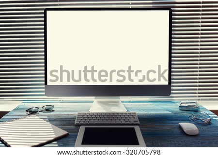 Mock up of office or home desktop with accessories and work tools, blank screen pc computer, keyboard with mouse, sunglasses, digital tablet, empty touch pad and headphones, modern hipster workspace