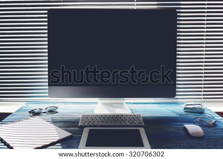 Mock up of office or home desktop with accessories and work tools, blank screen pc computer, keyboard with mouse, sunglasses, digital tablet, empty touch pad and headphones, modern hipster workspace