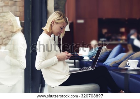 Modern business woman or successful working on smart phone and laptop computer at coffee shop interior, female student sitting in university library while using technology, internet distance work