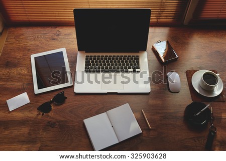 Mock up of hipster workplace with luxury accessories and distance work tools, laptop computer and digital tablet with blank copy space for text message or information content, net book and touch pad