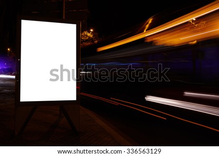 Illuminated blank billboard with copy space for your text message or promotional content, public information board in city with night light on background, advertising mock up banner on roadway
