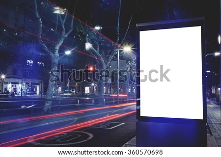 Electronic blank billboard with copy space for your text message or content, public information board with cars lights on background, advertising mock up in urban setting, empty poster on roadside
