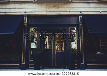 Exterior of luxury restaurant made of black wood with copy space area for your advertising text message or promotional content, central entrance to the prestigious expensive hotel in urban scene