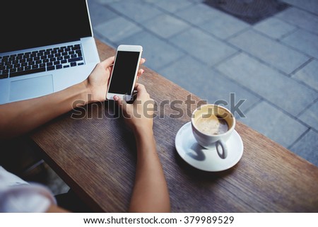 Closeup of women\'s hands holding cell telephone with empty copy space screen for your advertising text message or promotional content, female watching video on mobile phone during rest in coffee shop