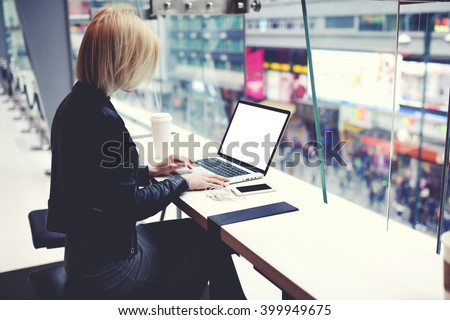 Female successful businesswoman is using for distance work laptop computer with empty copy screen for your advertising text message. Hipster girl is searching information on web page via net-book