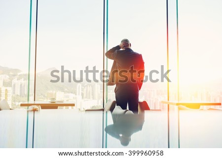 Back view of a man lawyer dressed in suit is resting after his a failed court hearing, while is standing in modern coffee shop interior against window with copy space background for your text message