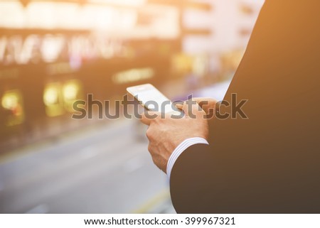 Closeup of a man`s hands is holding cell telephone with blank copy space screen for your advertising text message or information content. Businessman is reading news in internet via mobile phone