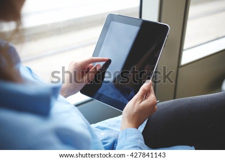 Closely image of woman`s finger is touching touch pad screen with copy space for your advertising text message or promotional content. Close up of hipster girl is downloading file on digital tablet