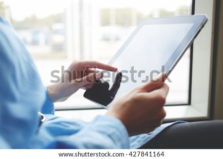 Closeup image of woman is booking on-line via portable digital tablet. Closely of female is searching needed file on her touch pad with copy space screen. Young hipster girl is using modern gadget