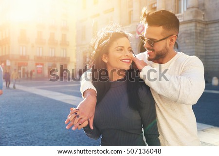 Happy young couple is spending vacation holidays in Barcelona city. Both look really happy. They are strolling along the streets of the old town and hanging out with pleasure, seeing attractions.