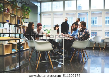 Group of casually dressed businesspeople discussing ideas in the office. Creative professionals gathered at the meeting table for discuss the important issues of the new successful startup project