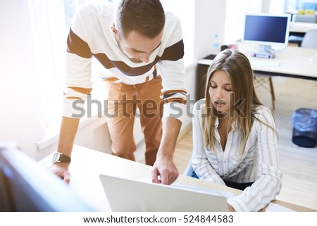 Two business partners accounting data information about success of corporation using laptop,internet connection while sitting in workshop with blank screen computer for your advertising on background