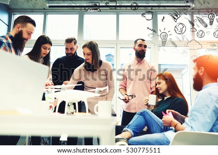 Group of young experts working on development of smart technologies and programs in modern loft. Office workers discuss job during coffee break. Infographics design elements of creative team ideas