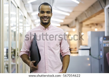 Portrait of cheerful male employee of media marketing company ready for hard working day in coworking office preparing documents and financial reports for showing executive on morning meeting