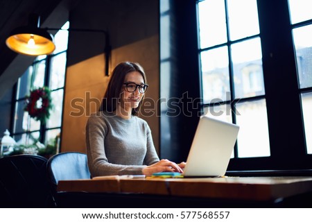 Skilled female software developer working on freelance use code libraries to simplify the transcription cooperating with advanced programmers adapt  application to systems platforms via laptop