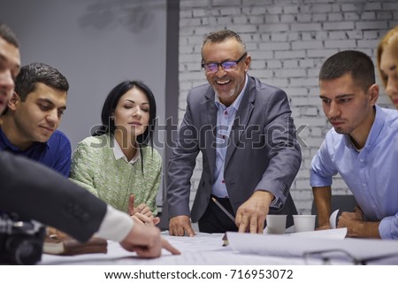Group of marketing experts dressed in formal wear developing advertising campaign while collaborating in office.Crew of creative designers discussing ideas and sharing opinions during work process