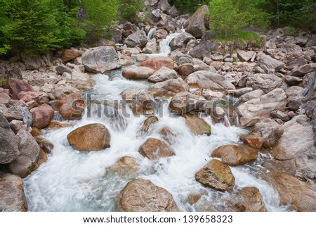 Cascades on the mountain river. Mountain stream runs over cascades and waterfalls.  Dovzan Gorge in Karavanke mountain range. Slovenia.