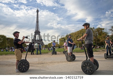 Paris, France - September 10: Group Of Tourists Take Snapshots In The Park Near The Eiffel Tower During Their Guided Segway Tour Of Paris In The Warm Autumn On September 10, 2011 In Paris, France.