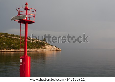 Little Red Lighthouse somewhere in the Adriatic sea, equipped with solar cell panel.