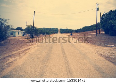 Long dirt country road. Vintage effect added for depressive mood.
