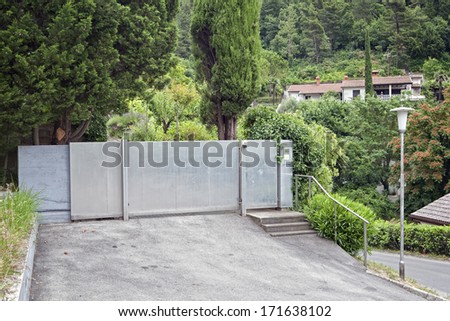 Metal Gates. Driveway to luxury house with automatic gates.