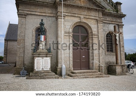 LANDEVANT, FRANCE - JULY 8, 2012: Church of St Martin in the city of Landevant in Brittany , France with crucifix on the right side and the WW1 memorial on the left side of the church door.