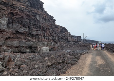 Group of tourists enjoying a guided walk through the Timanfaya National Park in Lanzarote. Visitors can observe spectacular volcanic landscape along the explanations of most competent guides.