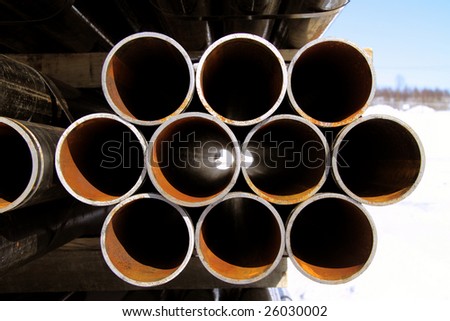 rust black pipes stacked in shipping yard canada