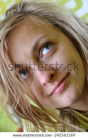 Portrait of a young face, messy hair, happy, smiling, pensive woman who is looking sideways and has messy hair